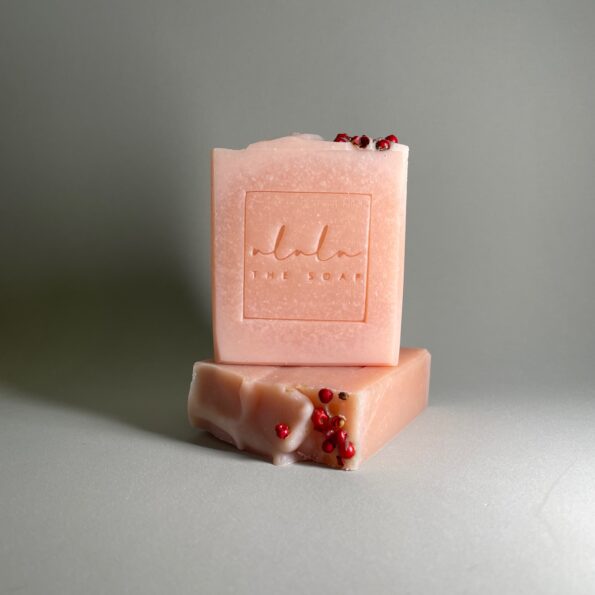 Sabonete artesanal de azálea e argila rosa sobre fundo neutro, com tom rosado e textura cremosa